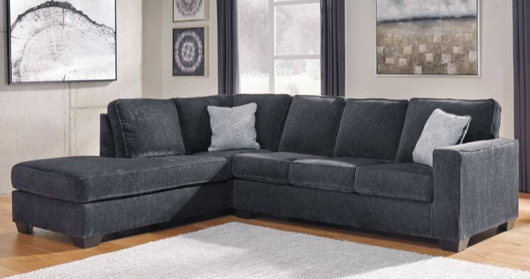 Dark gray sectional with light gray accent pillows.