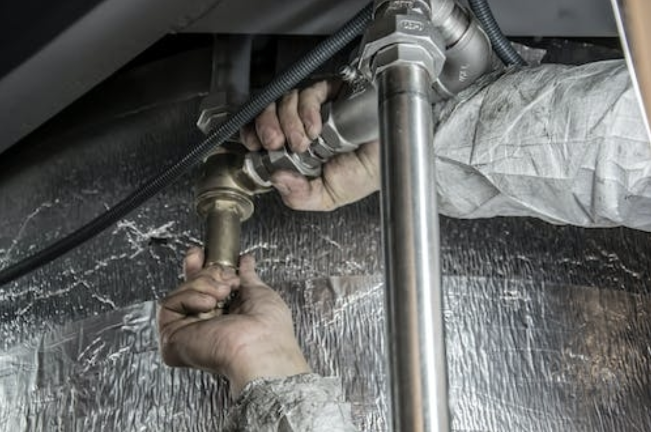 A plumber is fixing a broken pipe.