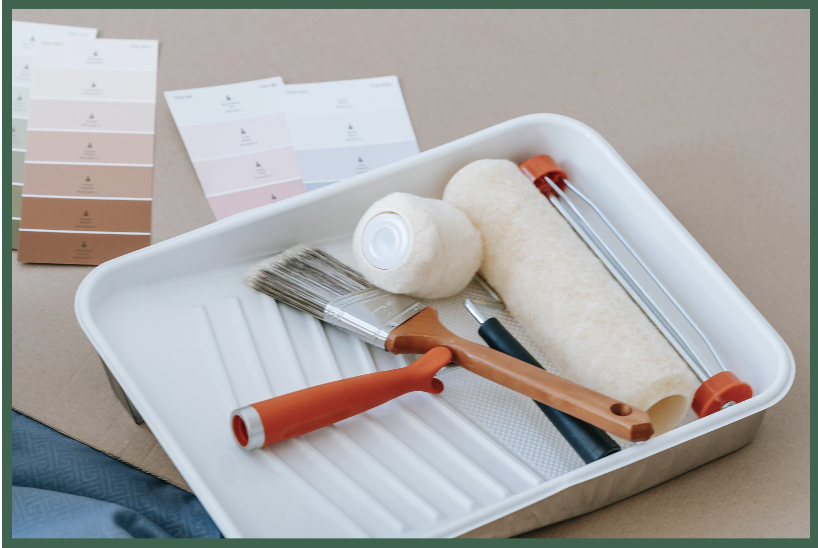Paint supplies including paint samples, brushes, rollers, and a paint tray.