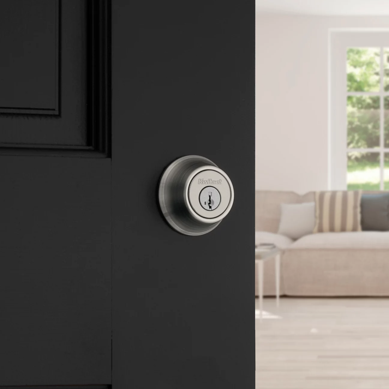 Satin chrome deadbolt on a black exterior door.