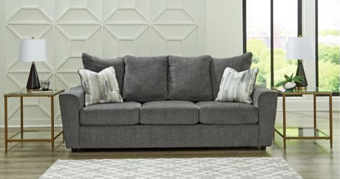 Gray three seater sofa with two accent pillows.